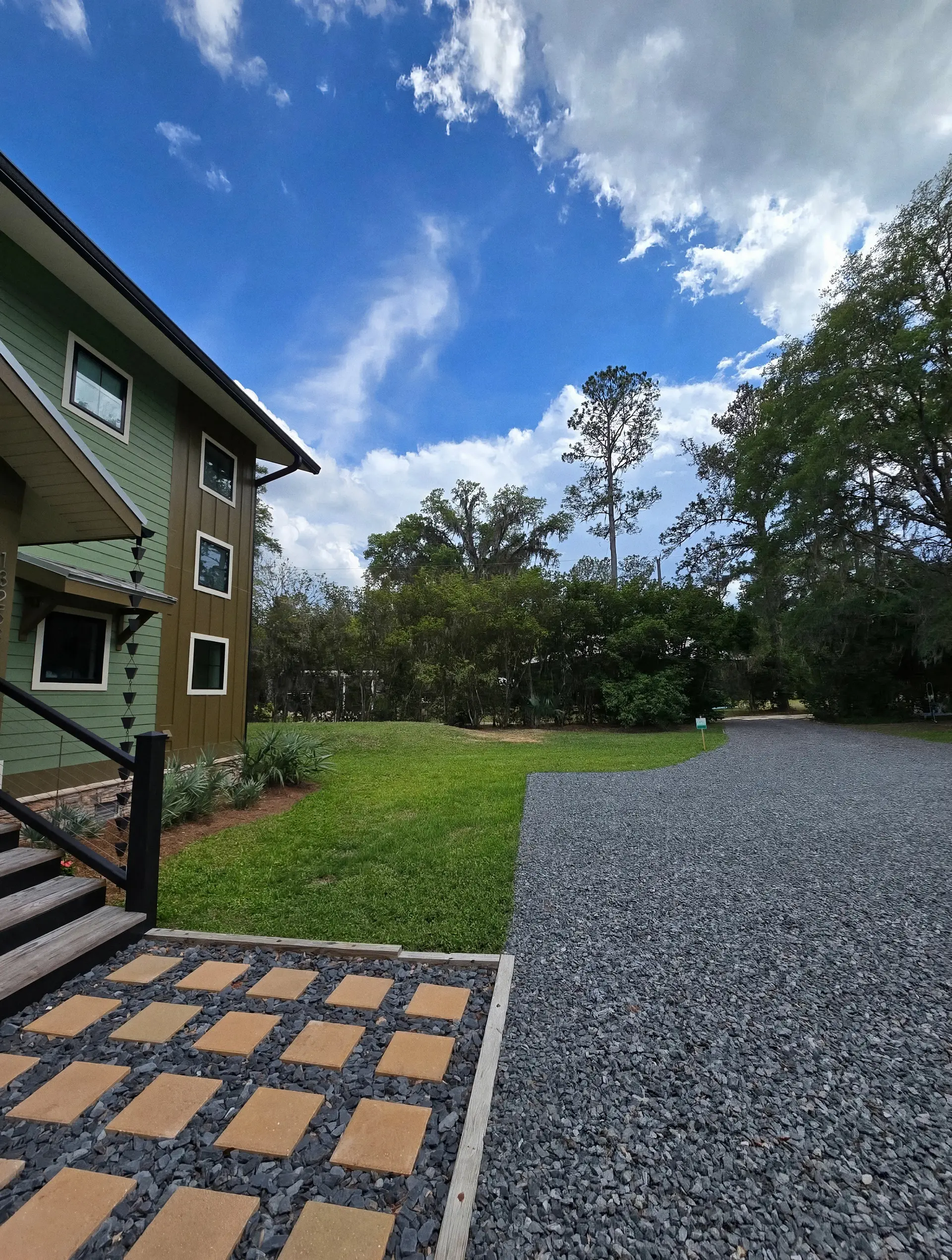 Neatly maintained lawn and gravel driveway beside a modern home in North Central Florida